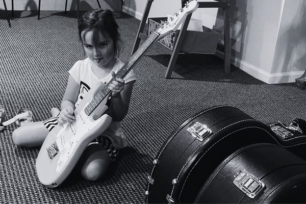 Young student learning guitar at home in New Jersey with private instructor